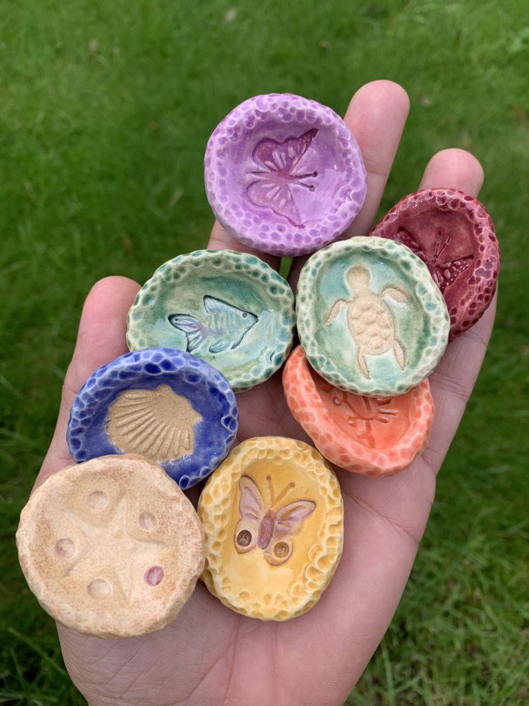 Handmade ceramic sensory stones with colourful glazes and nature-inspired motifs. Small, tactile pieces to hold, explore with your fingers and keep in your pocket